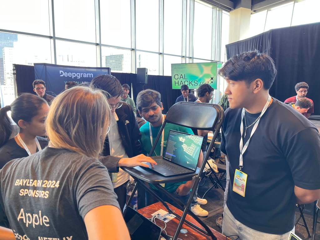 Pacific students show their Cal Hacks project to a judge.