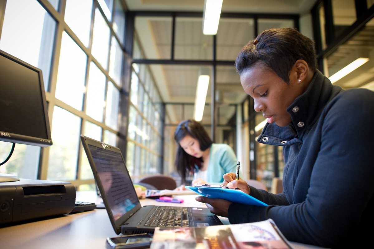College student uses time management skills to study productively in Pacific library.