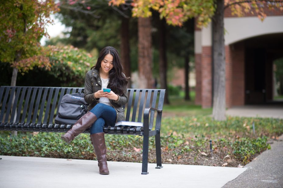 Pacific student checks her cellphone on campus.