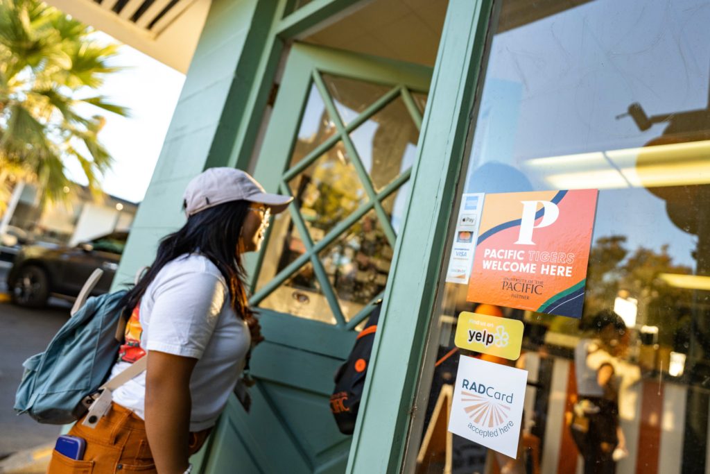 Student walks into a Miracle Mile shop during Pacific's “Tiger Prowlin’ the Mile” event during Week of Welcome.