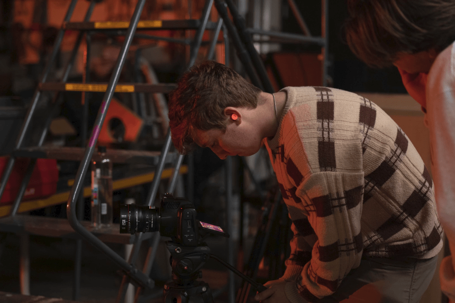 Pacific media student using a camera on a documentary set.